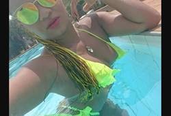 morena amadora de biquíni fio dental dançando na piscina